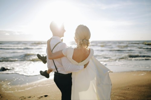 groom-holding-bride-on-beach